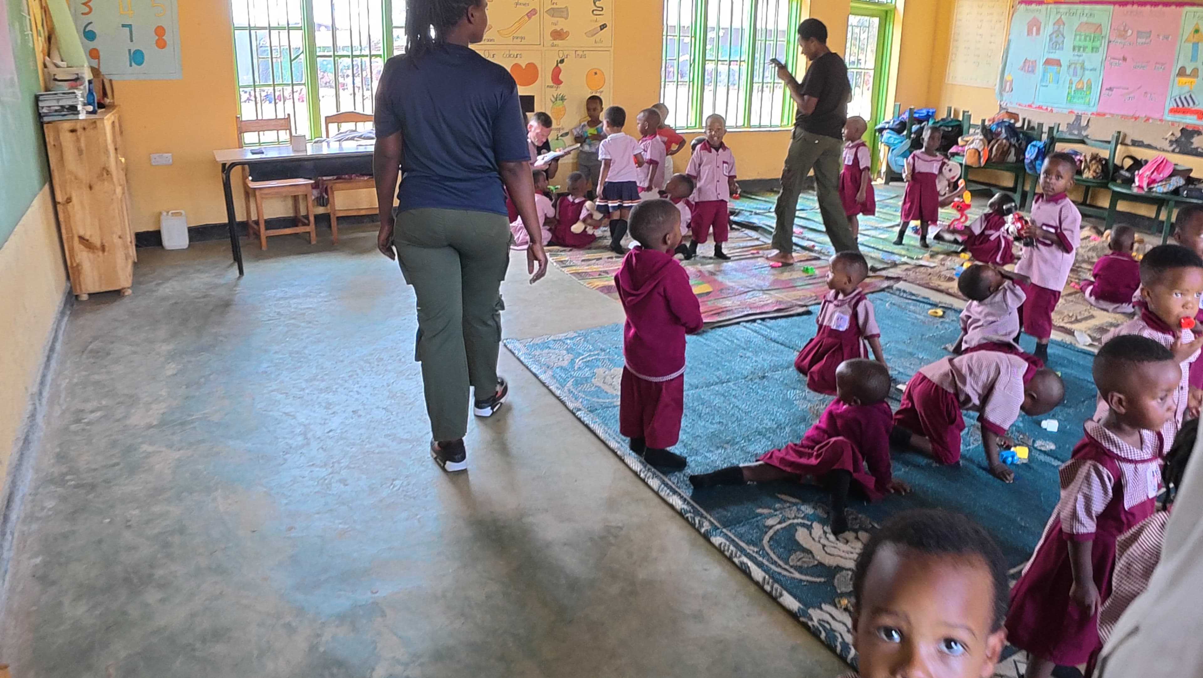 Nursery pupils learning with their teacher in class